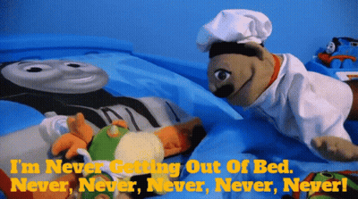 A Puppet Is Laying On A Bed With The Words " I 'M Never Getting Out Of Bed Never Never Never Never " GIF