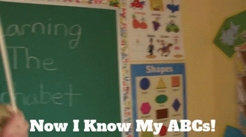 A Puppet Is Standing In Front Of A Chalkboard That Says Learning The Alphabet Now I Know My Abcs GIF