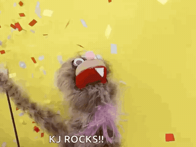 A Puppet Is Standing In Front Of A Yellow Background And Confetti Is Falling Around It . GIF