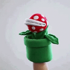 A Puppet Of A Carnivorous Plant Is Being Held By A Hand GIF