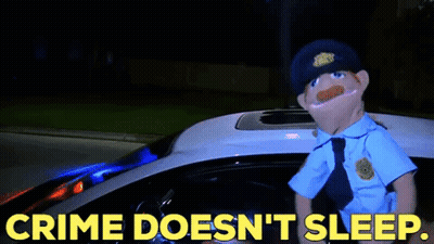 A Puppet Police Officer Is Standing In Front Of A Police Car With The Words Crime Does N't Sleep GIF