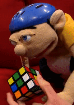 A Puppet Wearing A Blue Helmet Is Holding A Rubik 'S Cube GIF