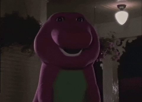 A Purple And Green Stuffed Animal With A Big Smile GIF