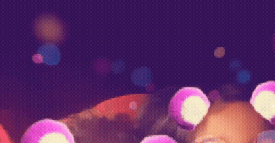 A Purple Background With A Bunch Of Pink Circles Floating In The Air GIF