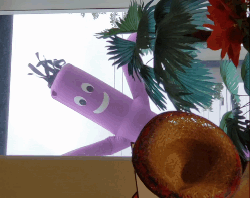 A Purple Balloon With A Smiley Face On It Is Hanging From The Ceiling GIF