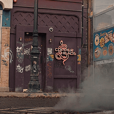 A Purple Building With A Neon Sign That Says Copper Heads On It GIF