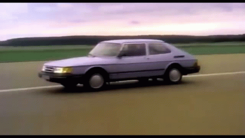 A Purple Car Is Driving Down A Road GIF