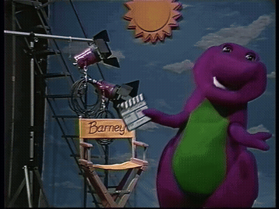 A Purple Dinosaur Is Standing Next To A Director 'S Chair With The Name Barney On It GIF