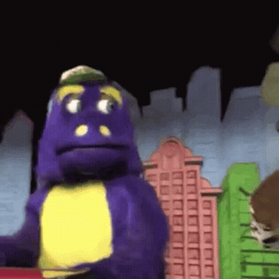 A Purple Dinosaur With A Yellow Chest Is Standing In Front Of A Cityscape . GIF