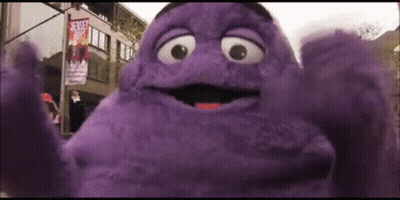 A Purple Mcdonald 'S Character Is Standing In Front Of A Street Sign That Says Street Art GIF