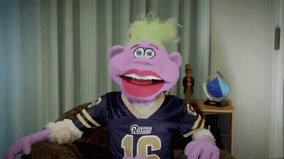 A Purple Puppet Wearing A Rams Jersey With The Number 12 On It GIF