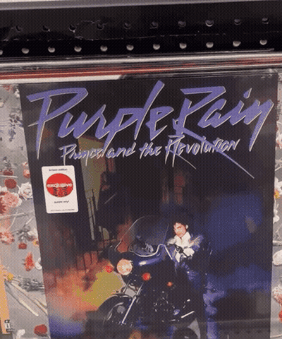 A Purple Rain Album Cover With A Man On A Motorcycle On It GIF