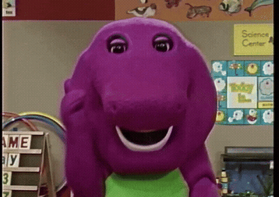 A Purple Stuffed Animal Is Smiling In Front Of A Science Center Sign GIF