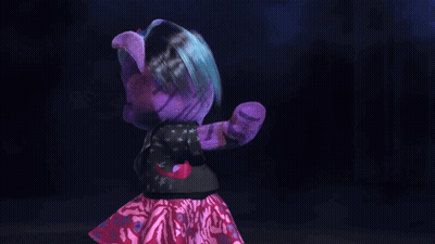 A Purple Teddy Bear Is Holding A Microphone And Pointing At The Camera GIF