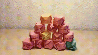 A Pyramid Of Pink And Yellow Origami Cubes GIF