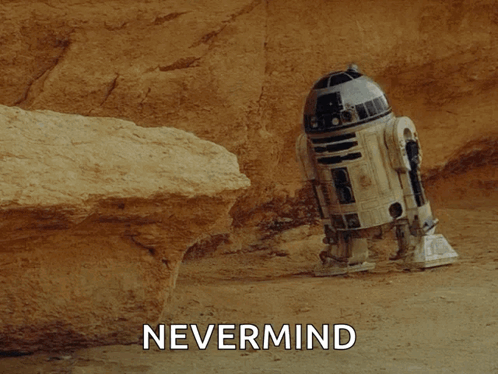 A R2d2 Robot Is Laying On The Ground Next To A Rock And The Word Nevermind Is Written Above It GIF