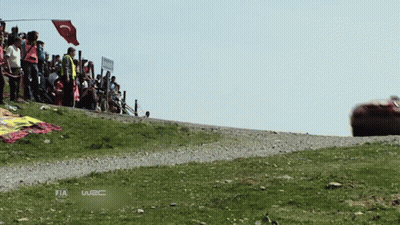 A Race Car Is Driving Down A Dirt Road With The Word Fia On The Bottom Right GIF