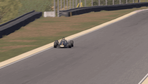 A Race Car Is Driving Down A Track With A Red And White Stripe GIF