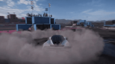 A Race Car Is Driving Down A Track With Smoke Coming Out Of The Back GIF