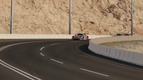 A Race Car Is Going Around A Curve In The Road GIF