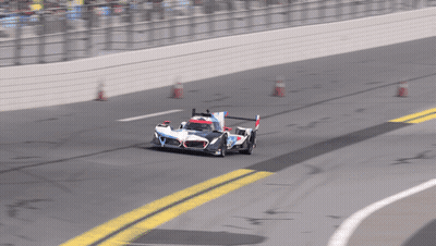 A Race Car Is Going Around A Curve On A Race Track GIF