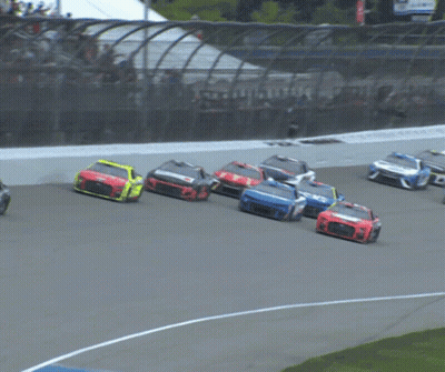 A Race Car With A Blue Stripe On The Side Is Driving Down A Track GIF