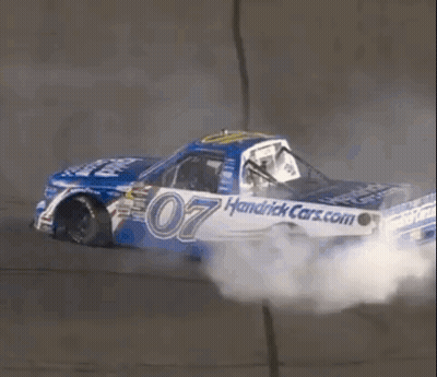A Race Car With The Number 07 On It Is Driving Down A Track . GIF