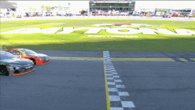 A Race Track With A Large Daytona Logo In The Background GIF
