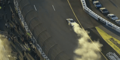 A Race Track With The Word Geico On The Side Of It GIF