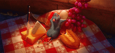 A Rat Is Sitting On A Checkered Table Cloth Next To A Bunch Of Grapes GIF