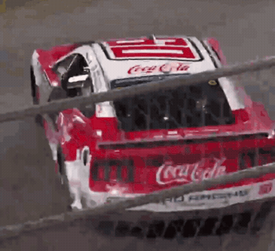 A Red And White Coca Cola Race Car Is Going Down A Track GIF