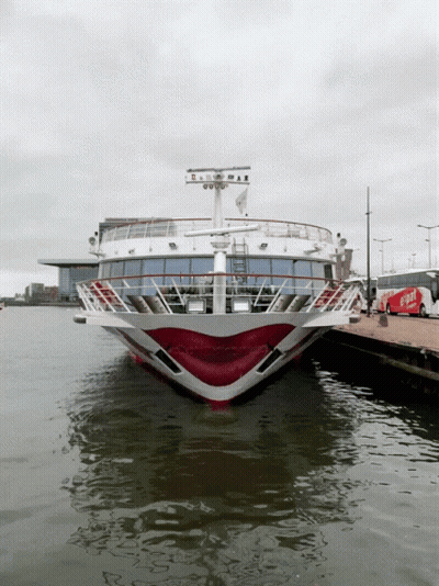 A Red And White Cruise Ship Is Docked At A Pier GIF