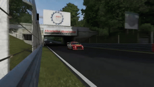 A Red And White Honda Racing Car Is Driving Down A Track GIF