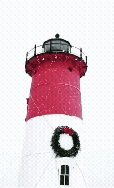 A Red And White Lighthouse With A Wreath On Top GIF