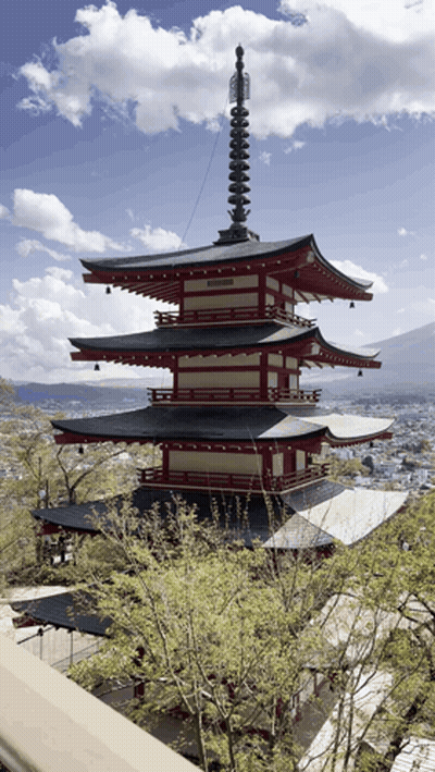 A Red And White Pagoda With A Clock On Top GIF