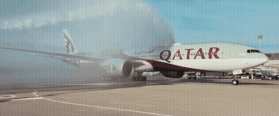 A Red And White Qatar Airplane Is Parked On The Runway GIF