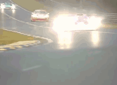 A Red And White Race Car Is Driving Down A Road With A Fence In The Background GIF
