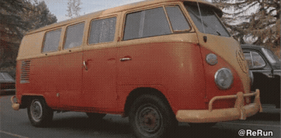 A Red And Yellow Van Is Parked In A Parking Lot With The Watermark @Rerun GIF