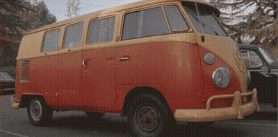 A Red And Yellow Van Is Parked On A Street GIF