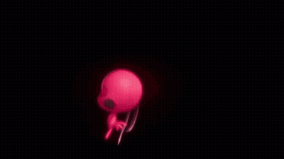 A Red Ant And A Black Cat Are Standing Next To Each Other In The Dark . GIF