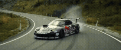 A Red Bull Race Car Is Driving Down A Curvy Road GIF