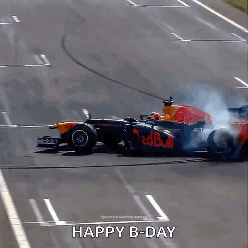 A Red Bull Race Car Is Driving Down A Track With Smoke Coming Out Of The Tire GIF