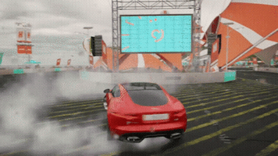 A Red Car Is Doing A Burnout In Front Of A Large Screen With The Letter O On It GIF