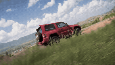 A Red Car Is Driving Down A Dirt Road GIF
