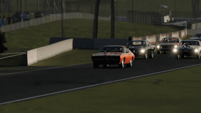 A Red Car Is Driving Down A Race Track GIF