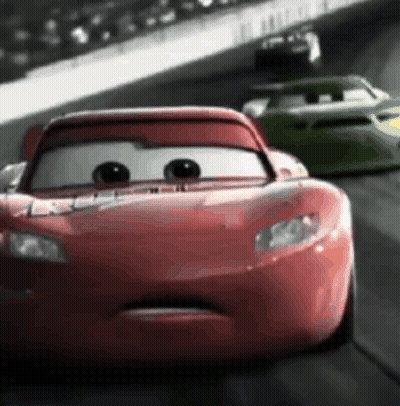 A Red Car Is Driving Down A Race Track With A Green Car Behind It . GIF