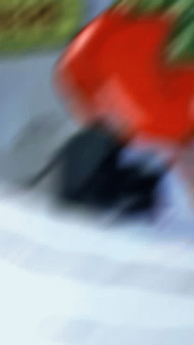 A Red Car Is Driving Down A Road With A Blue Sky In The Background GIF