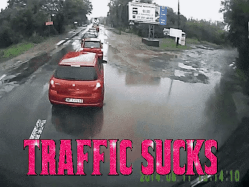 A Red Car Is Driving Down A Wet Road With The Words Traffic Sucks Written In Pink GIF