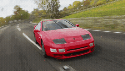 A Red Car Is Driving On A Curvy Road GIF