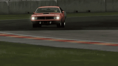 A Red Car Is Driving On A Race Track With A Chevrolet Sign In The Background GIF